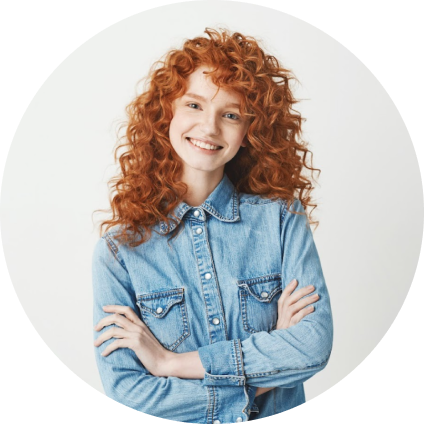 mulher branca ruiva sorrindo e com os braços cruzados